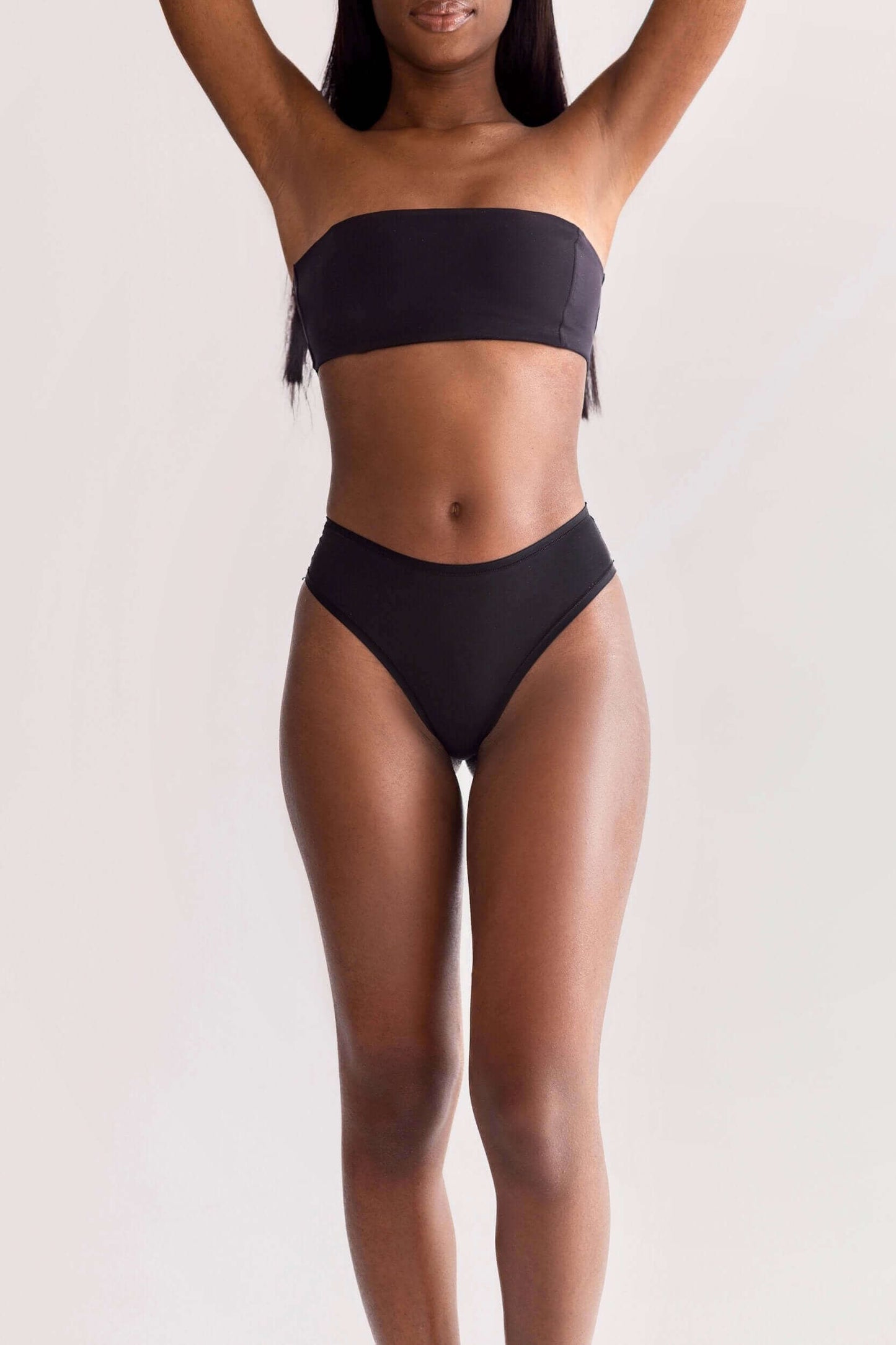 Model wearing UNDRESSE Medium-Waist Thong in Black Front Side