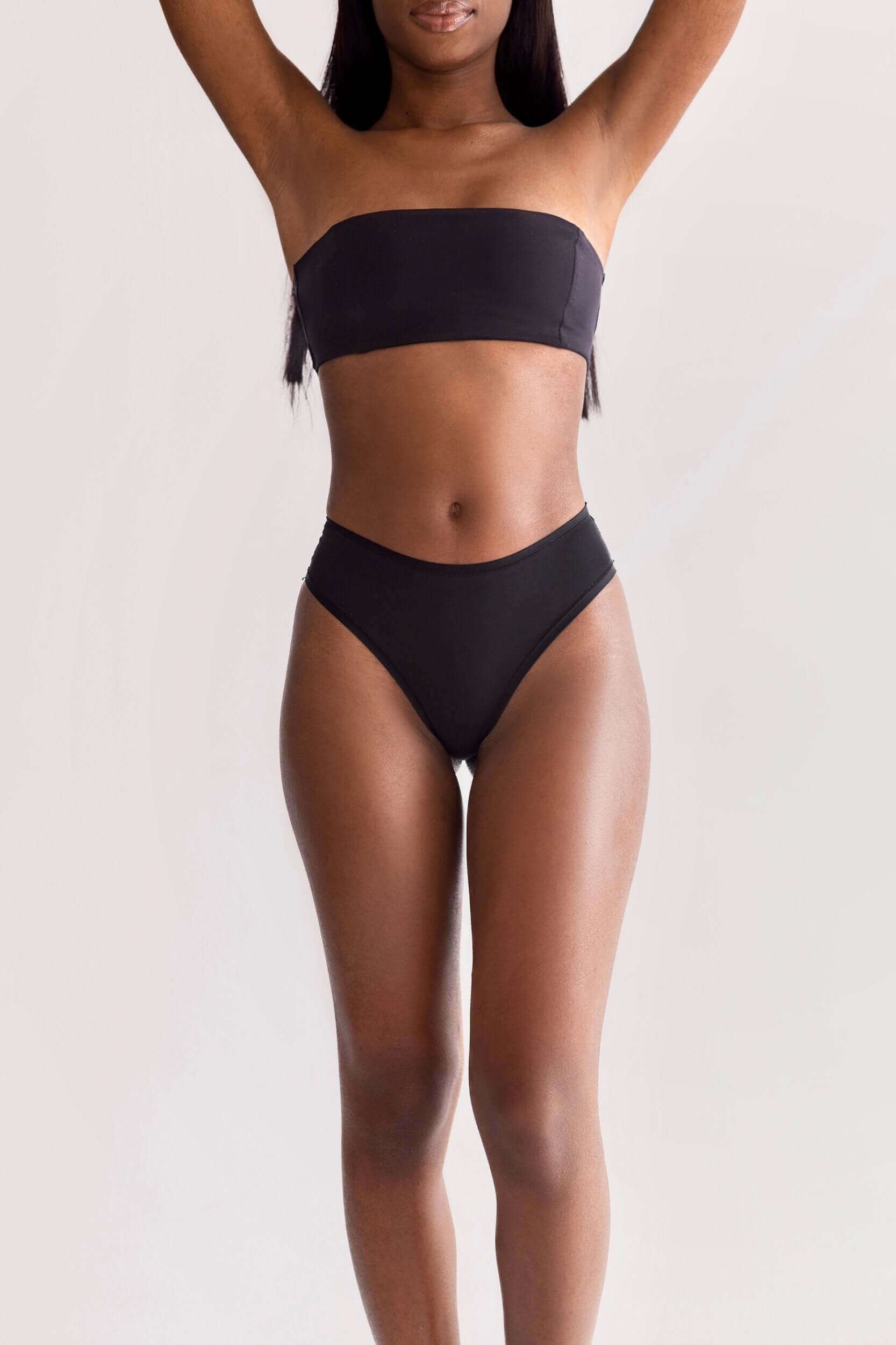Model wearing UNDRESSE Medium-Waist Thong in Black Front Side